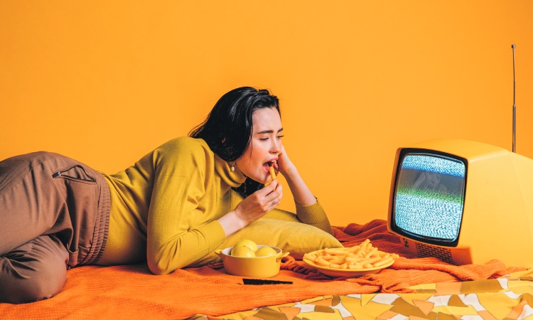 Noia menjant amb TV