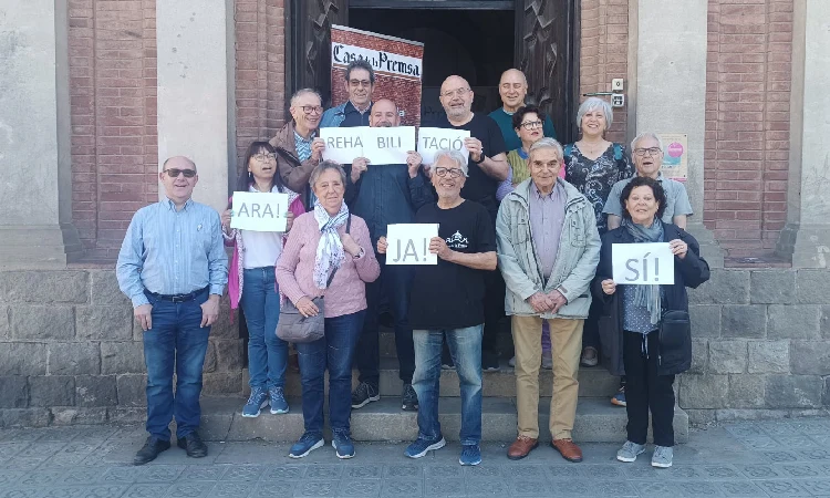 Grup de Veïns davant de la Casa de la Premsa amb cartells de "Rehabilitació" "Ja" i "Ara"