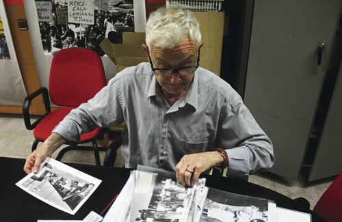 Josep Maria Monferrer observa fotografies que s’exposaran a La vida al Camp de la Bóta. Foto: Línia Nord