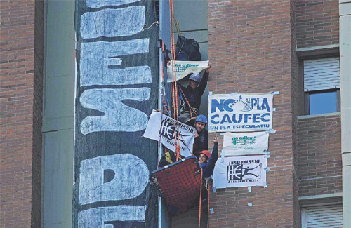 Activistes contra el Pla Caufec es pengen durant una protesta en un edifici. Foto: No al Pla Caufec
