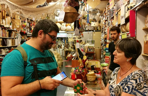 Un usuari de l’aplicació en una botiga de Sants-Montjuïc. Foto: Districte