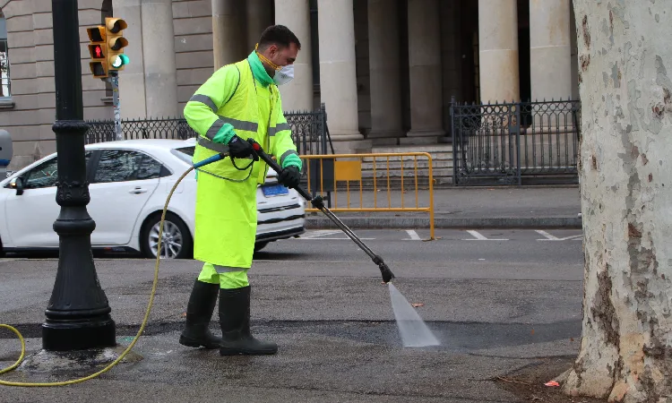 treballador netejant carrer amb aigua freàtica